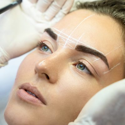 Woman during professional eyebrow mapping procedure Young woman during professional eyebrow mapping procedure